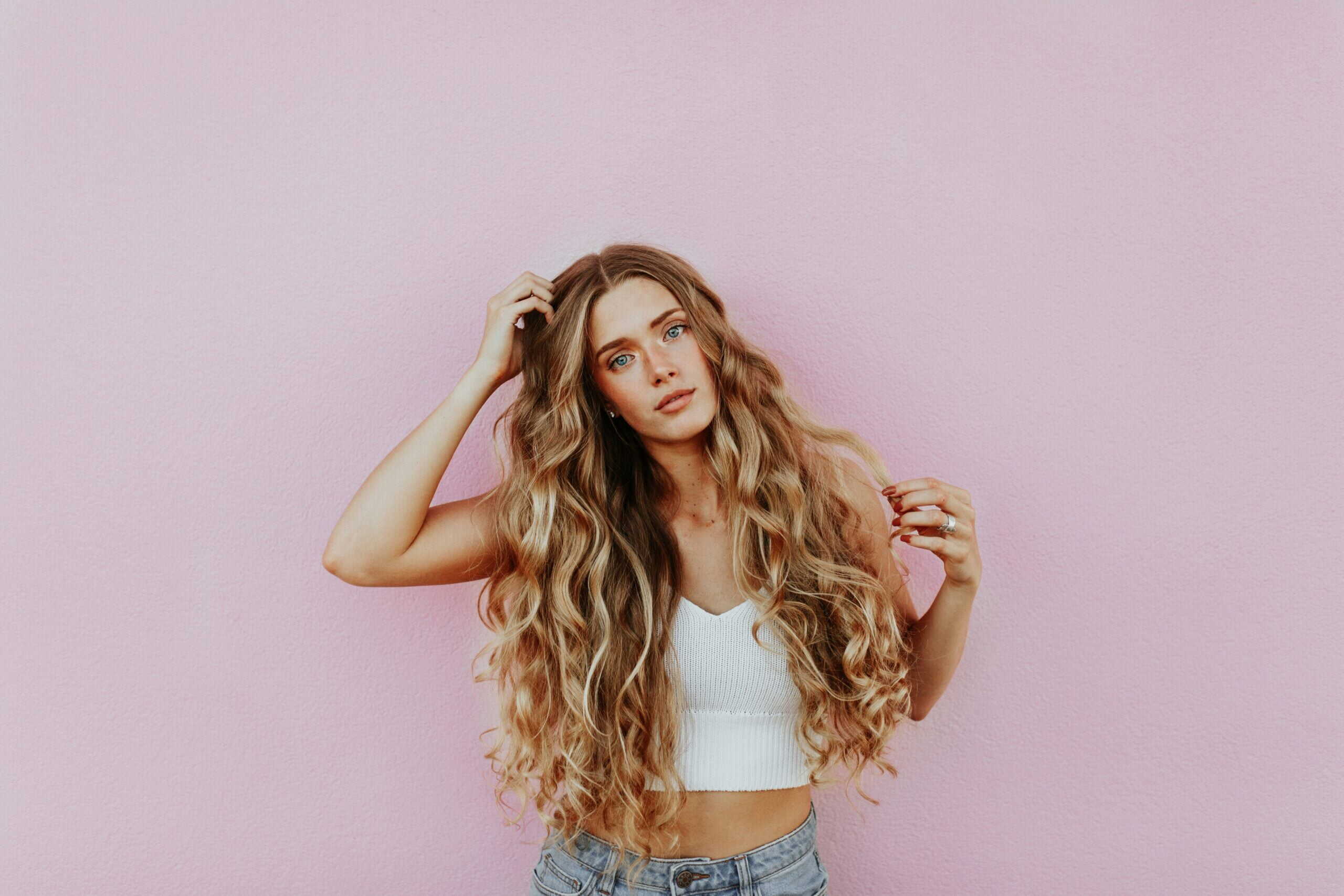 A woman with a hand on her hair and thinking