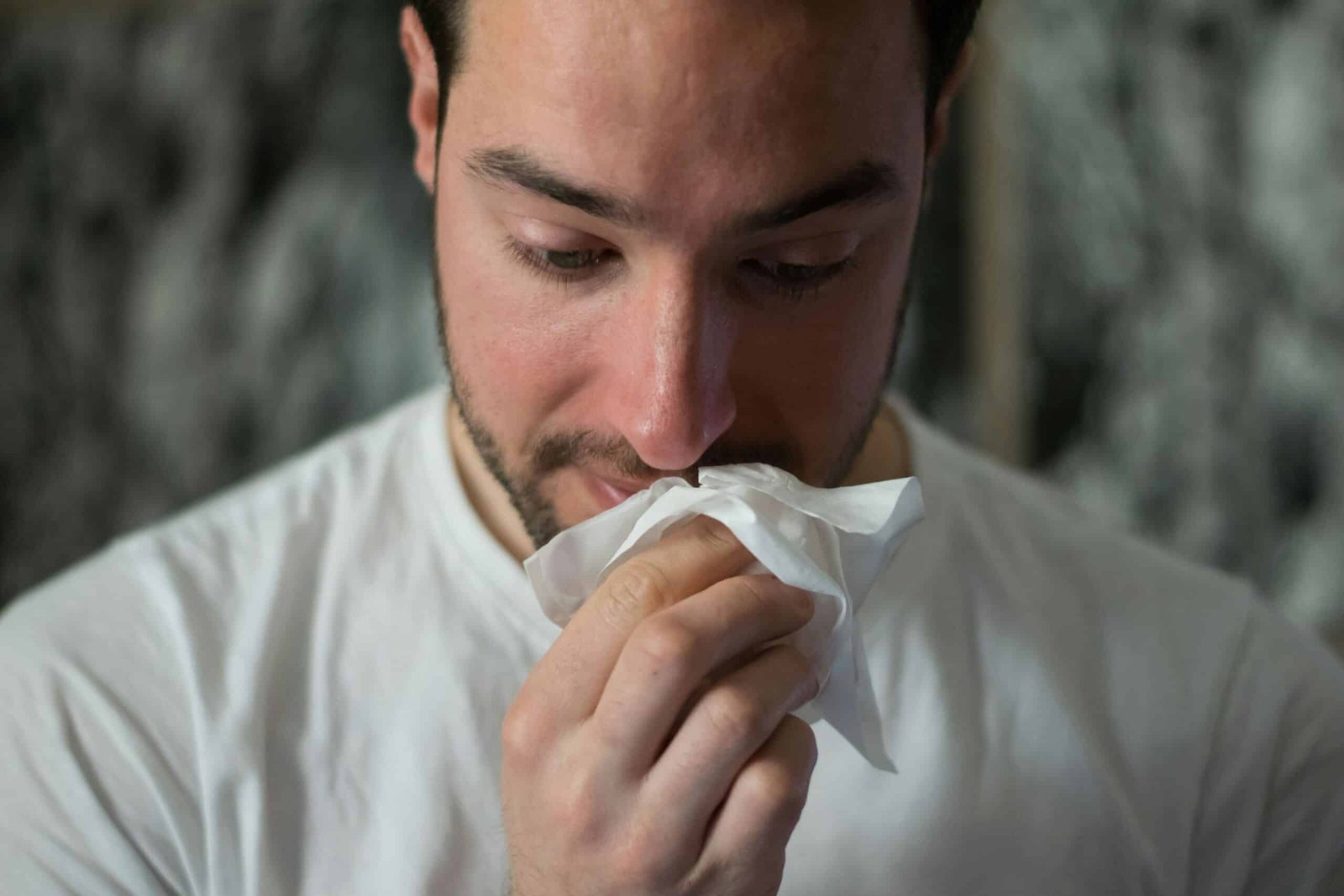 A man sneezing due to allergy and asthma