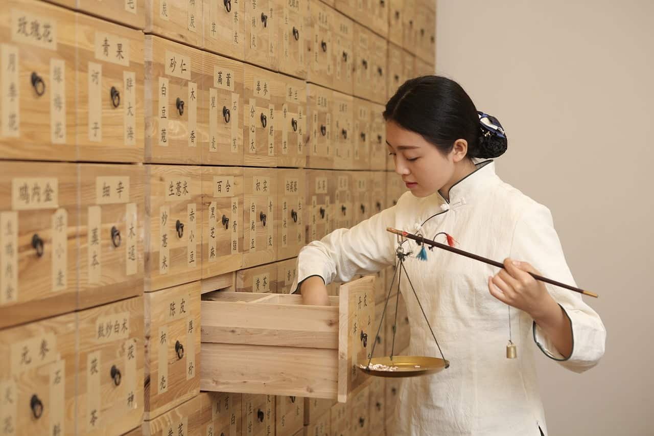 Showing an east Asian woman trying to treat patients with the help of Traditional Chinese Medicine (TCM)