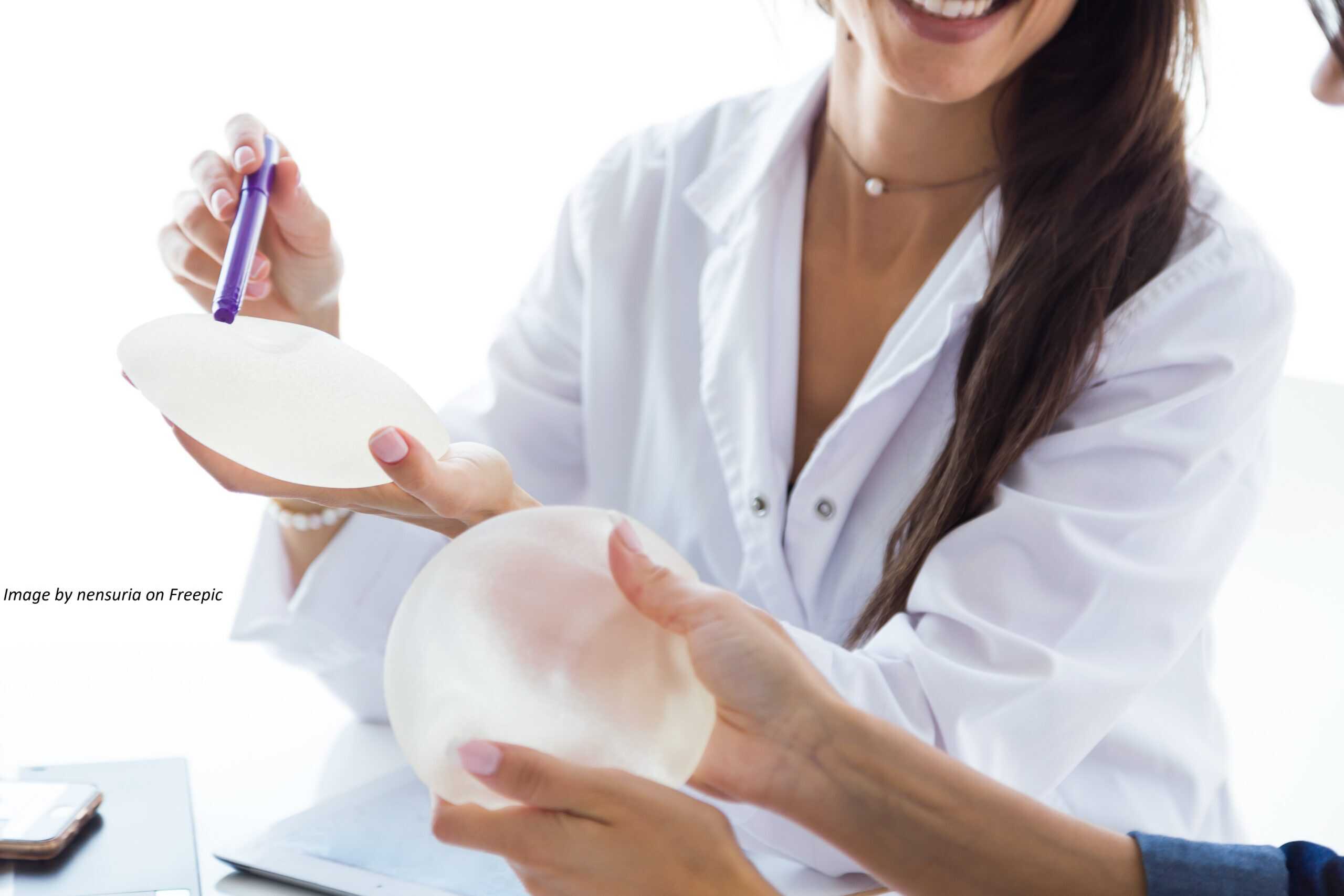 Portrait of doctor and her patient choosing mammary prosthesis in the office.