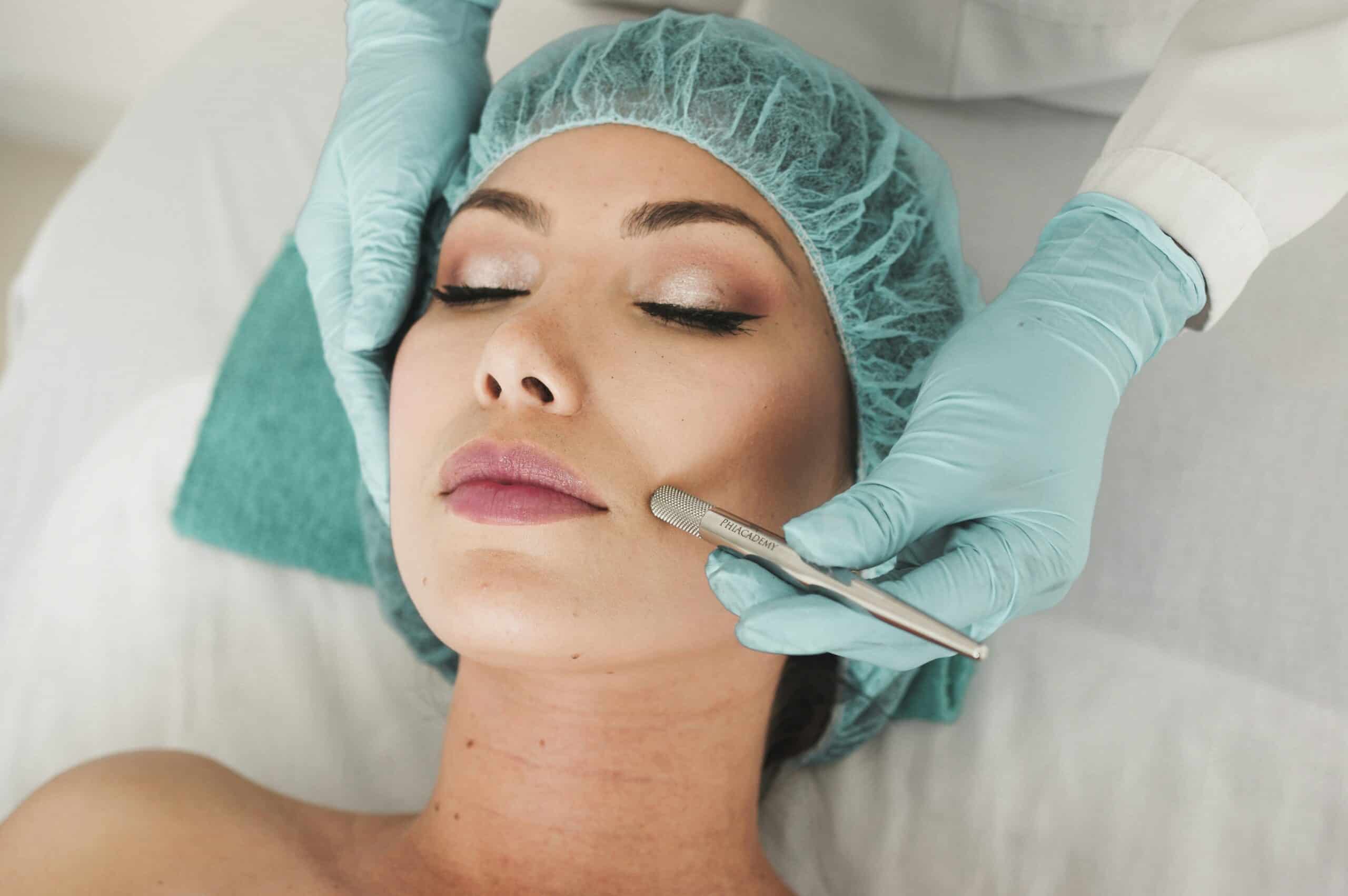 A woman with the hands of her doctor on her face getting ready for a cosmetic surgery