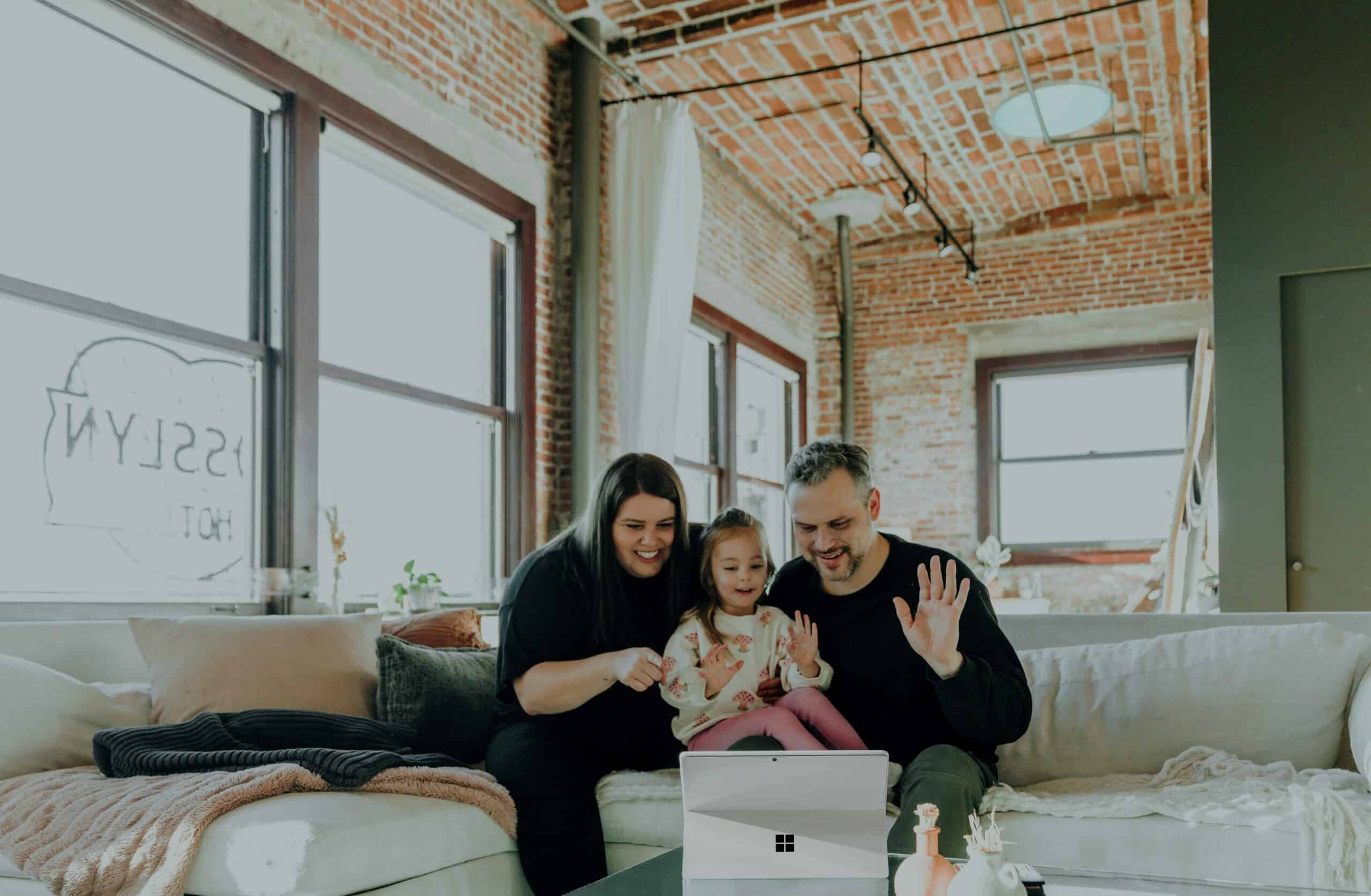 A family sitting on a sofa speaking with their doctor via telemedicine tools