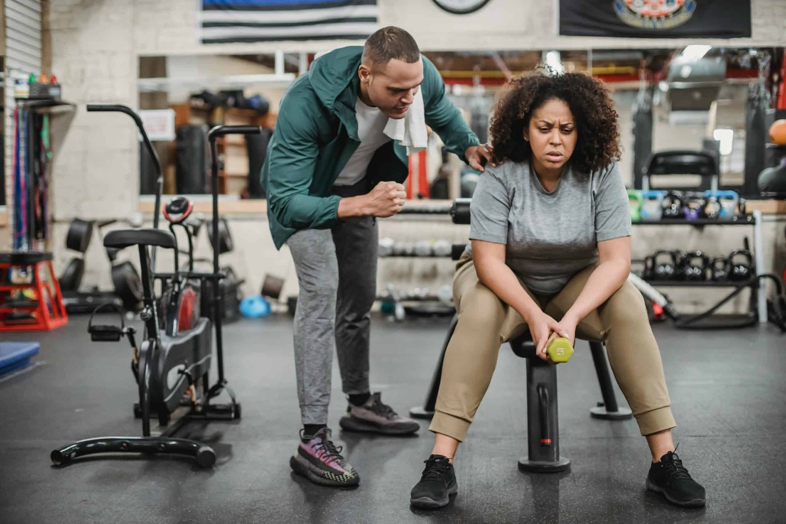 An obese and tired woman sitting on a chair in a gym